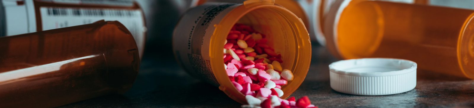 Open potje medicijnen verspreid over tafel